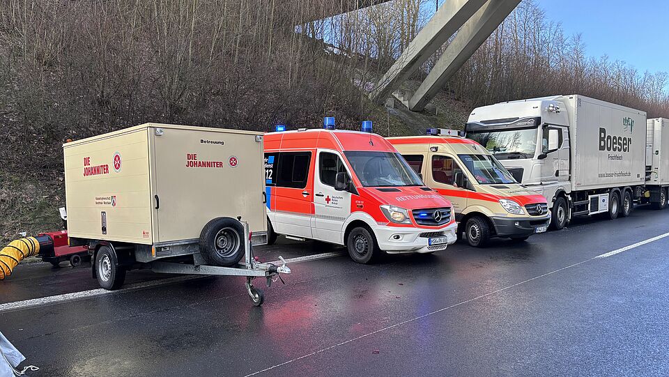 3398 Auf der Bundesautobahn 44 stehen zwei Einsatzfahrzeuge und ein Einsatzanhänger in einer Reihe. Im Hintergrund steht ein LKW auf dem Seitenstreifen. Eine Brücke erstreckt sich über die BAB 44