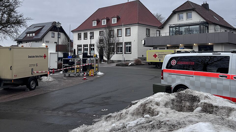 3389 Auf dem Dorfplatz in Meerhof stehen Einsatzfahrzeuge der Betreuungs- und Sanitätskomponente.
